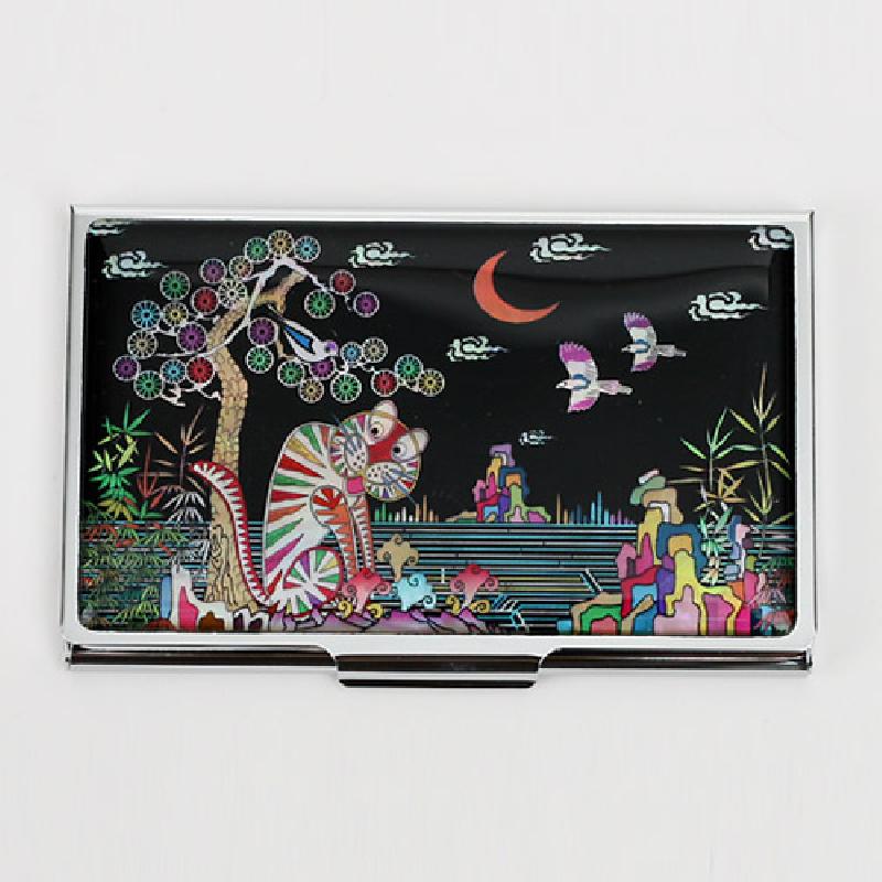 흑색 옻칠 바탕에 자개 상감으로 표현한 까치와 호랑이, 산수와 구름·달 문양이 다채로운 색감으로 장식된 금속 명함집.