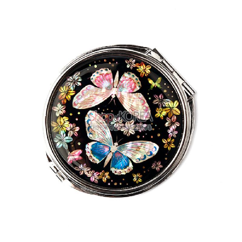 흑색 바탕 위에 자개 상감 기법으로 나비와 꽃 문양을 넣은 원형 금속 손거울.