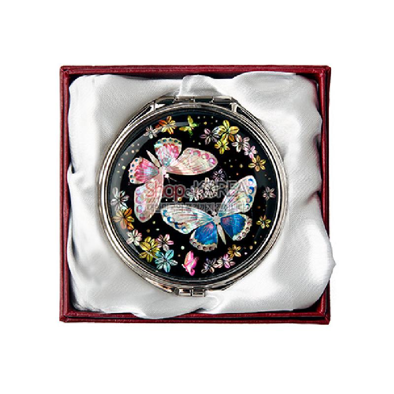 검은 바탕 위 자개 상감 기법으로 표현된 나비와 꽃 문양이 돋보이는 원형 금속 손거울.