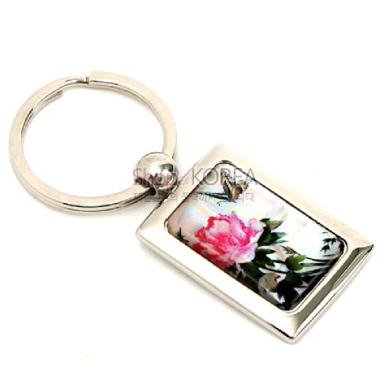 금속 사각 프레임과 자개판에 분홍 담화와 나비 문양을 담은 옻칠 열쇠고리.