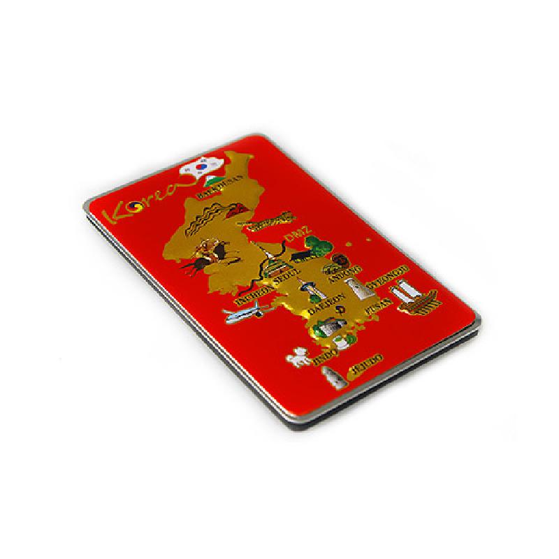 붉은 바탕 위에 금색 대한민국 지도와 주요 관광지 아이콘을 금속 양각으로 표현한 직사각형 메모홀더. 붉은 바탕 위에 금색 대한민국 지도와 주요 관광지 아이콘을 금속 양각으로 표현한 직사각형 메모홀더.