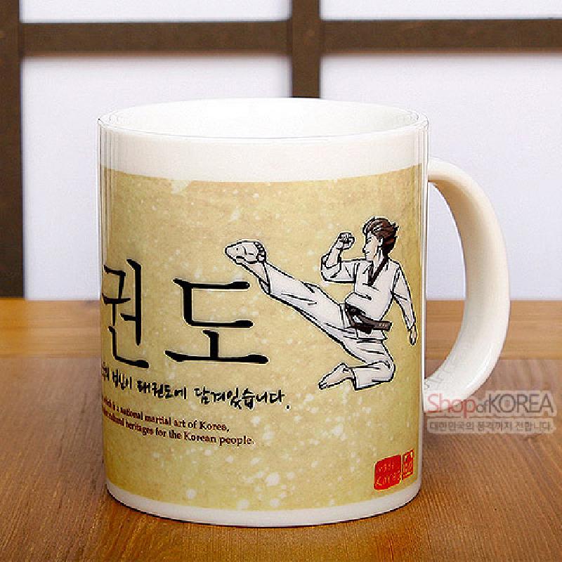 아이보리색 도자 재질에 노란 바탕, 태권도 동작 일러스트와 한글 서체 장식이 특징인 머그컵. 아이보리색 도자 재질에 노란 바탕, 태권도 동작 일러스트와 한글 서체 장식이 특징인 머그컵.