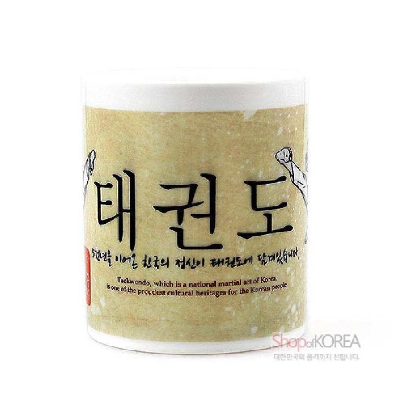 크림색 바탕에 태권도 한글 서체와 흑백 일러스트가 인쇄된 세라믹 머그컵. 크림색 바탕에 태권도 한글 서체와 흑백 일러스트가 인쇄된 세라믹 머그컵.