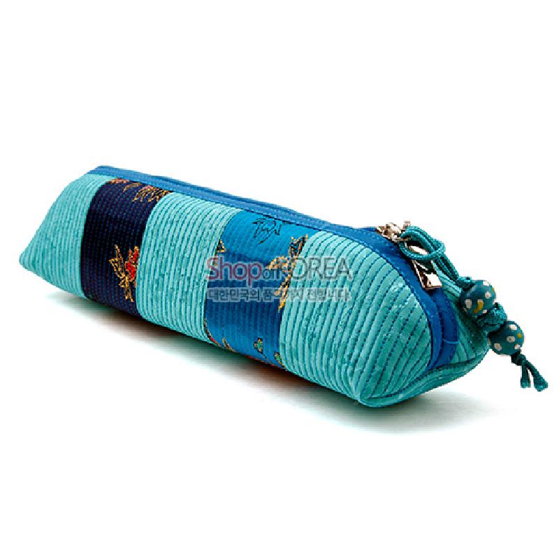 청색과 청록색 실크 소재의 누빔 기법으로 제작된 꽃무늬 패치워크 원통형 필통, 매듭 끈과 나무 구슬 장식 특징.