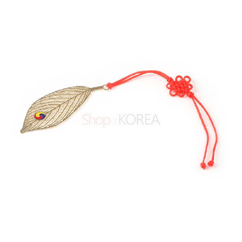 금속 재질의 나뭇잎 모양 책갈피와 태극 문양 장식, 붉은색 전통 매듭 끈이 연결된 디자인.