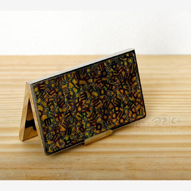 금속 재질 위에 다채로운 색상의 한글 자모 기하학 문양이 촘촘히 배치된 명함집.