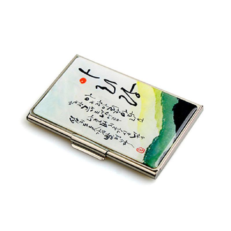 금속 틀 위에 백색 바탕과 녹색·노랑 수묵 그라데이션, 아리랑 글씨와 한글 서예 문양이 인쇄된 명함집. 금속 틀 위에 백색 바탕과 녹색·노랑 수묵 그라데이션, 아리랑 글씨와 한글 서예 문양이 인쇄된 명함집.
