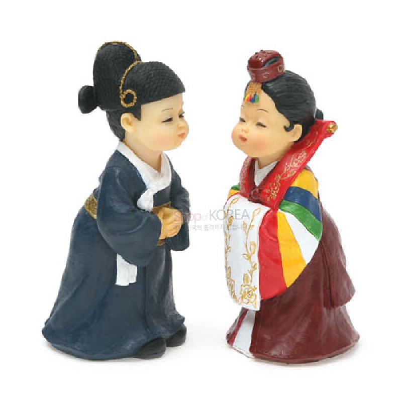 전통 혼례복 차림의 신랑신부를 형상화한 레진 인형 세트, 다채로운 색동 소매와 금색 자수 문양이 돋보이는 디자인.