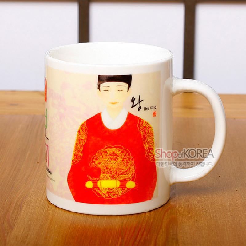 흰 도자기 머그컵에 붉은 곤룡포와 금빛 용 문양을 입은 왕 일러스트가 인쇄된 디자인.