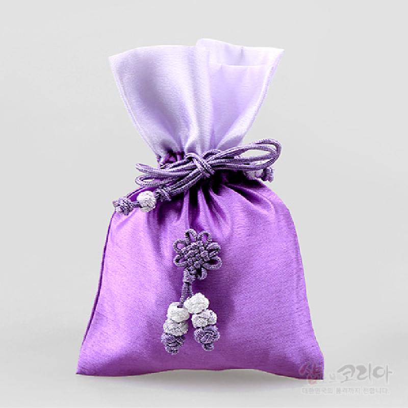 연자색과 연보라색 비단 재질에 전통 매듭 장식과 구슬 장식이 더해진 복주머니형 주머니. 연자색과 연보라색 비단 재질에 전통 매듭 장식과 구슬 장식이 더해진 복주머니형 주머니.
