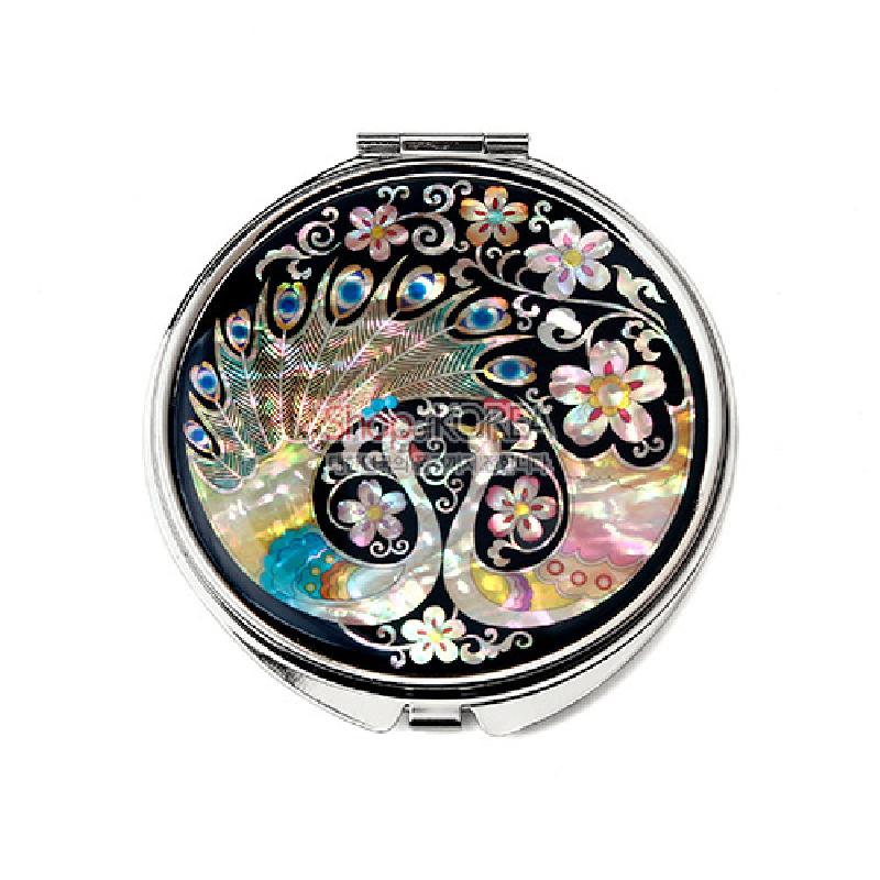 자개 상감 기법으로 공작과 꽃무늬를 표현한 원형 금속 손거울, 흑색 바탕에 오팔색과 파스텔톤 자개빛이 돋보이는 디자인.