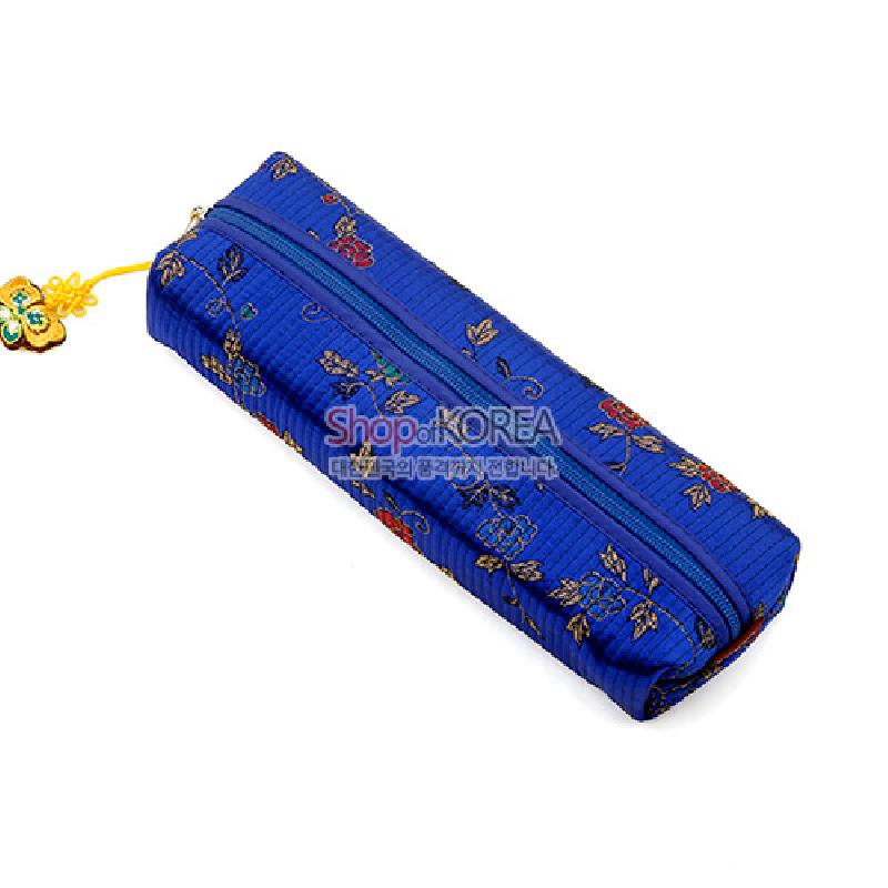 청색 누비 원단에 전통 꽃과 보자기 문양 자수로 장식된 직사각형 필통, 매듭 장식 지퍼 손잡이 특징. 청색 누비 원단에 전통 꽃과 보자기 문양 자수로 장식된 직사각형 필통, 매듭 장식 지퍼 손잡이 특징.