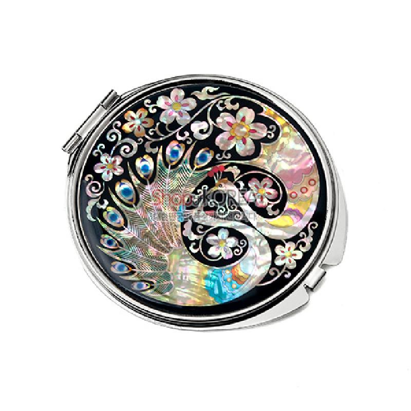 흑색 옻칠 바탕에 자개 상감 기법으로 공작과 연화, 꽃덩굴 문양을 넣은 원형 금속 손거울.