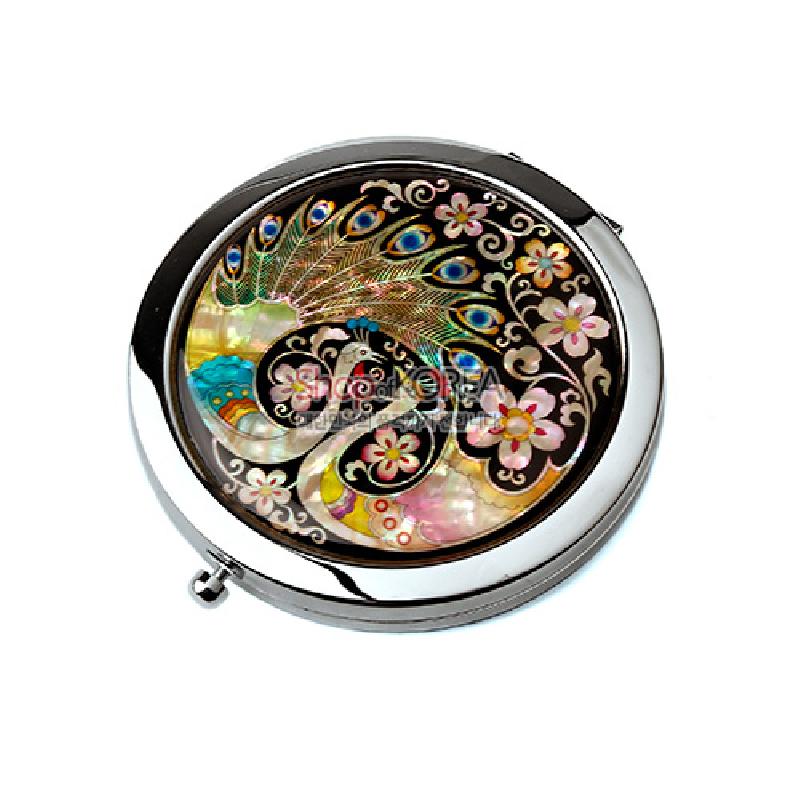자개 상감 기법으로 공작과 꽃문양을 표현한 원형 메탈 손거울, 화려한 오색 자개와 흑색 대비가 돋보이는 디자인. 자개 상감 기법으로 공작과 꽃문양을 표현한 원형 메탈 손거울, 화려한 오색 자개와 흑색 대비가 돋보이는 디자인.