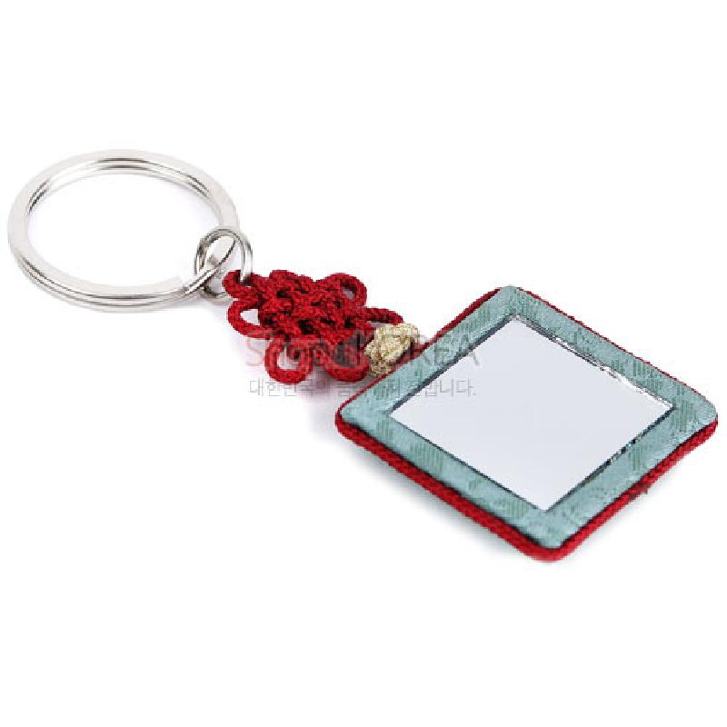 옥색 전통 조각보 원단과 빨간색 동심매듭 장식, 금속 링이 어우러진 사각 거울 열쇠고리. 옥색 전통 조각보 원단과 빨간색 동심매듭 장식, 금속 링이 어우러진 사각 거울 열쇠고리.