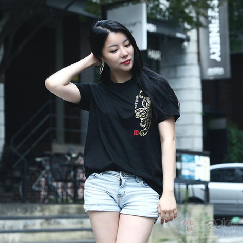 검은 면 소재에 금색 3D 입체발포 기법으로 표현된 호랑이 문양과 붉은 낙관 장식이 돋보이는 반소매 티셔츠.