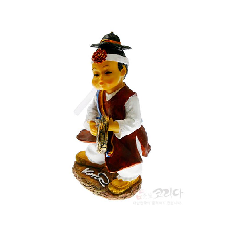 전통 의상을 입은 인물이 금속 꽹과리를 들고 있는 수지 재질의 채색 인형 조형물.