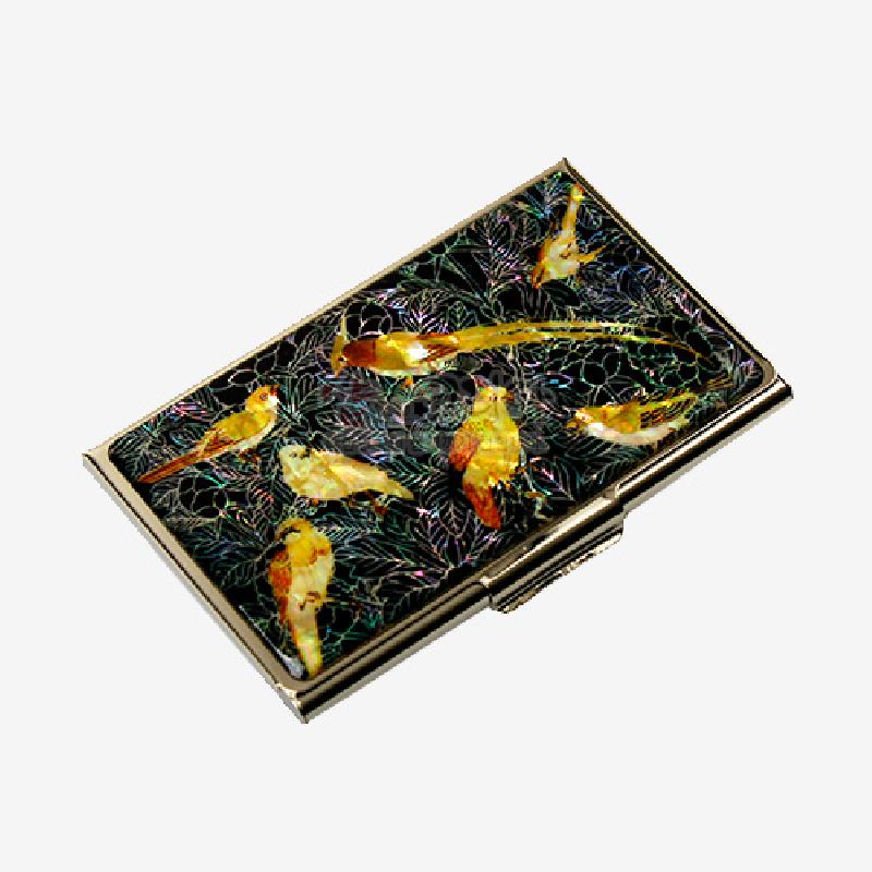 검은 바탕 위 자개 상감으로 표현된 황금빛 새와 꽃나무 문양이 특징인 금속 명함집. 검은 바탕 위 자개 상감으로 표현된 황금빛 새와 꽃나무 문양이 특징인 금속 명함집.