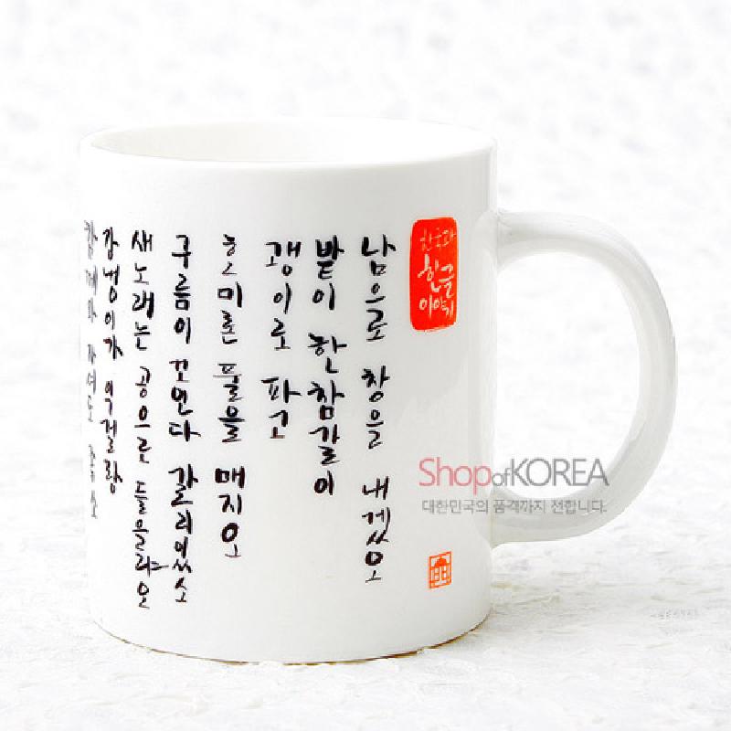 백자 느낌의 흰색 도자 재질에 검은색 한글 캘리그래피와 붉은 낙관 문양이 인쇄된 머그컵.