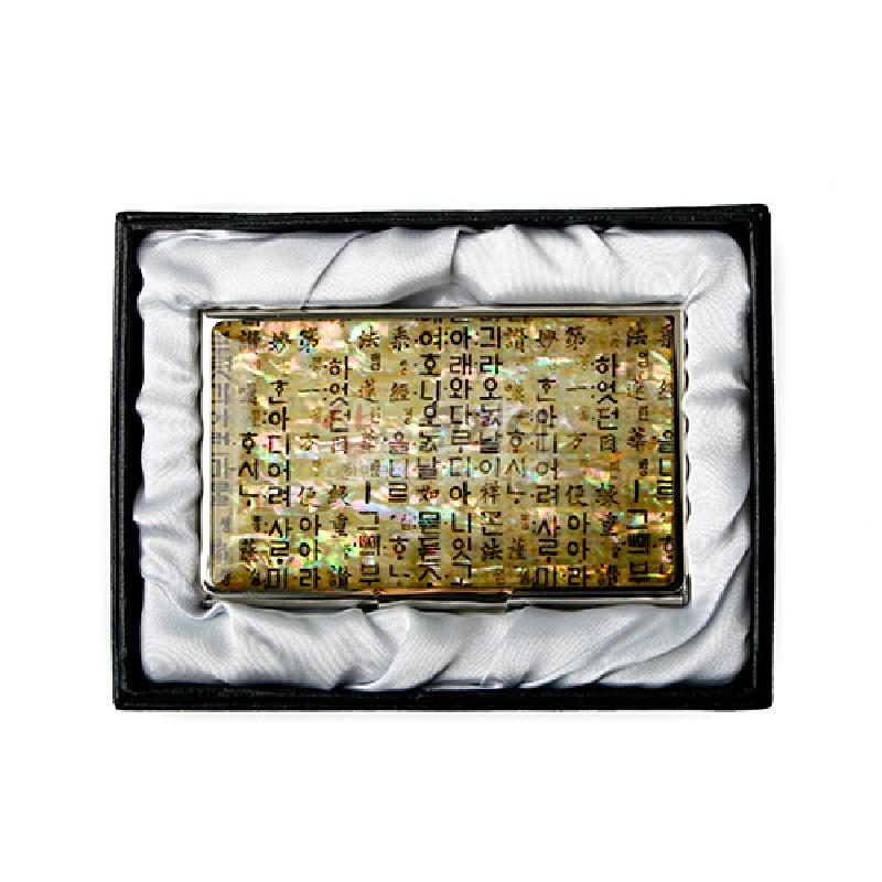 자개와 금속 재질 위에 황금빛 한지 배경과 훈민정음 글자 문양이 상감된 명함집.