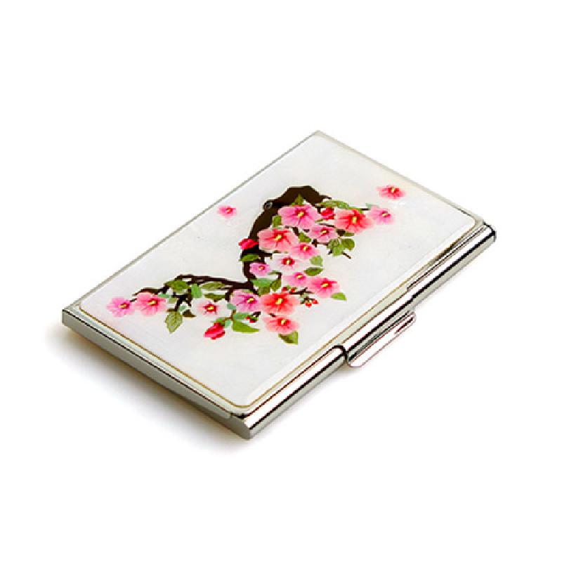 금속 테두리에 흰 바탕을 두고 분홍색 꽃과 초록 잎이 그려진 가지 문양이 특징인 명함집.
