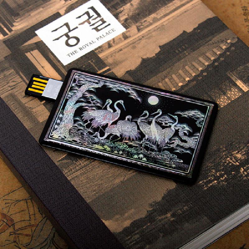 자개 상감 기법으로 흑색 바탕 위에 군학도와 소나무, 구름 문양을 담은 카드형 USB 메모리. 자개 상감 기법으로 흑색 바탕 위에 군학도와 소나무, 구름 문양을 담은 카드형 USB 메모리.