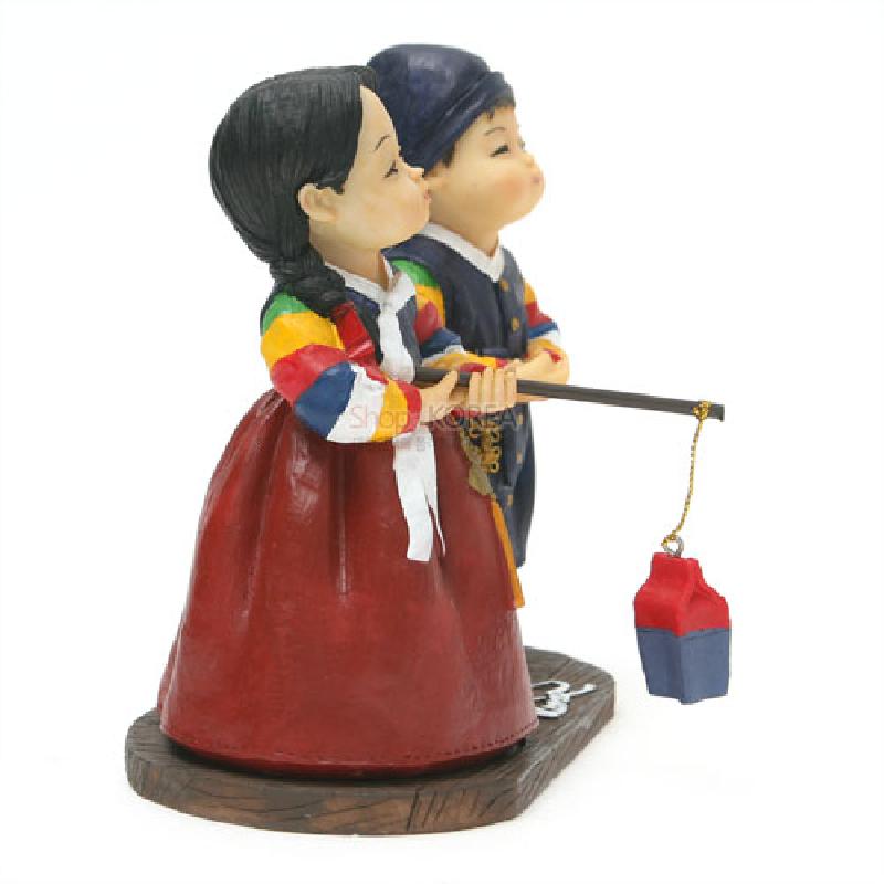 전통 한복 차림 남녀 아이가 청사초롱을 든 모습의 레진 소재 조형물, 오방색 저고리와 붉은 치마 색채 대비가 특징인 인형 장식.