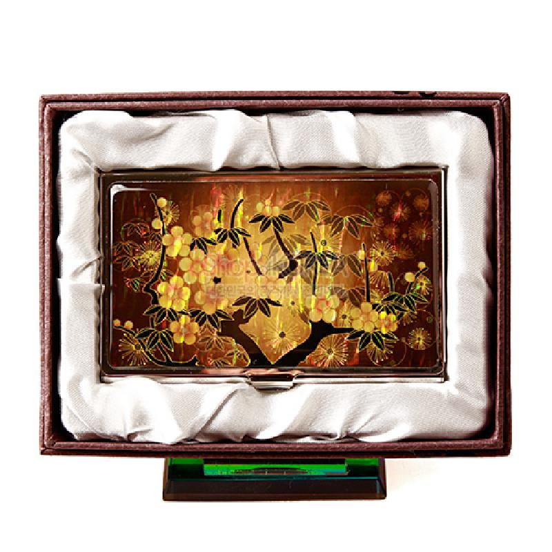 황색 바탕에 자개 상감 기법으로 매화와 잎사귀 문양을 넣은 금속 명함케이스.