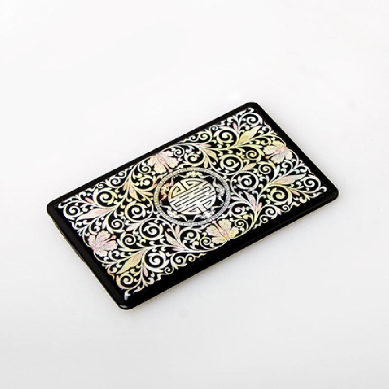 검은 옻칠 바탕에 자개 상감으로 표현된 당초무늬와 복문 원형 장식이 돋보이는 카드형 USB 메모리.