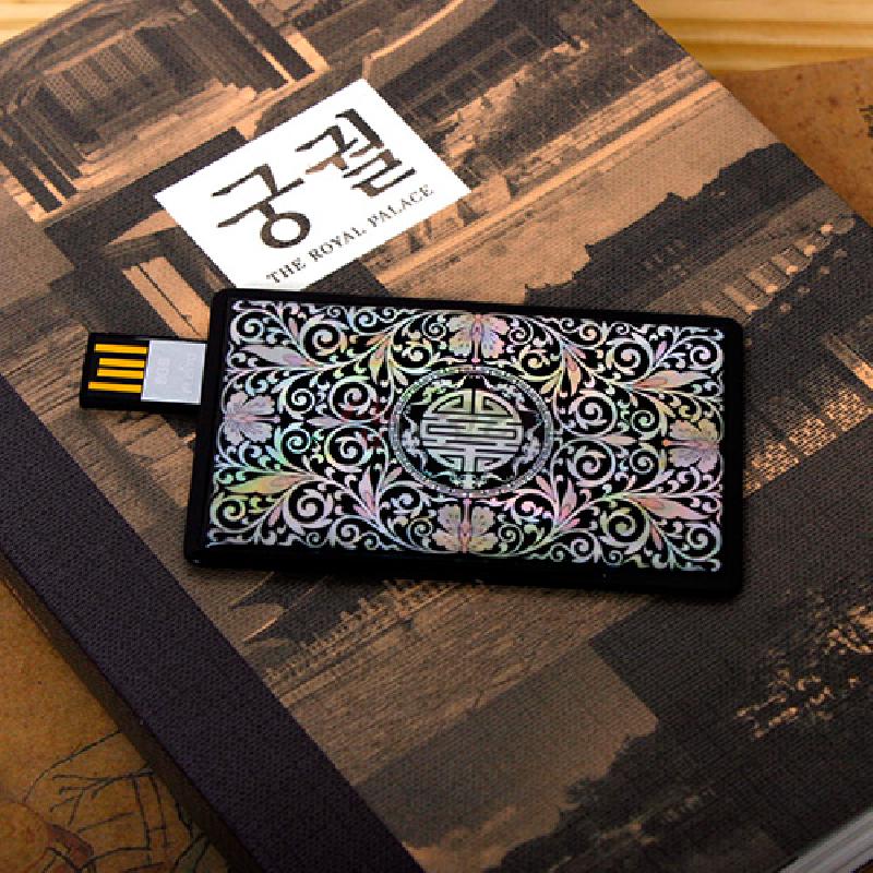 검은 바탕 위에 자개 상감으로 당초무늬와 원형 수자 문양을 넣은 카드형 USB 메모리.