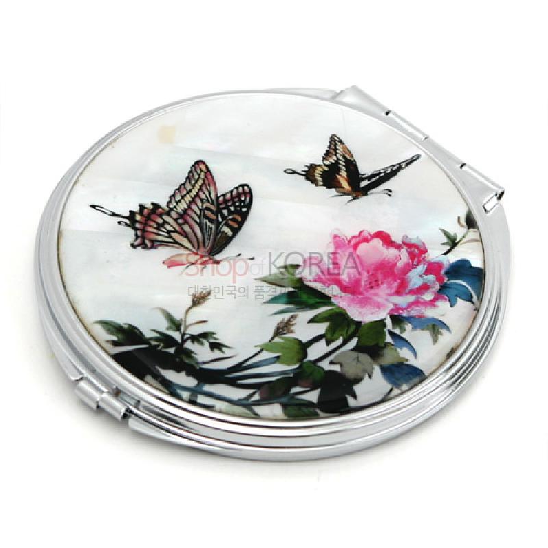 자개 바탕 위에 채색된 모란 꽃과 나비 문양이 있는 원형 금속 손거울.