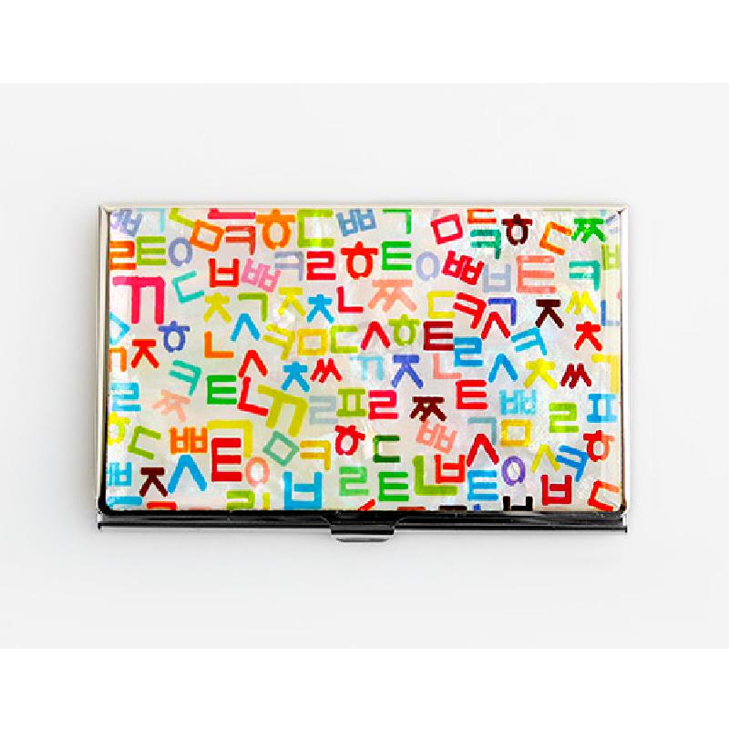 금속 재질 바탕에 흰색 배경과 다채로운 색상의 훈민정음 자음 문양이 반복된 명함케이스.