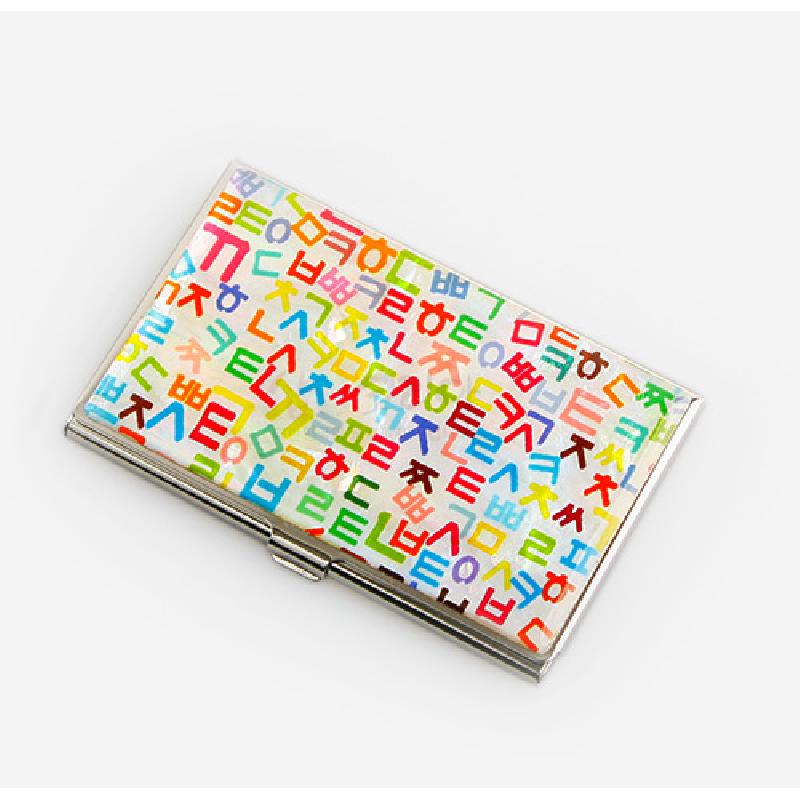 은빛 금속 테두리에 흰 바탕과 다채로운 색상의 훈민정음 자음 패턴이 인쇄된 명함케이스.