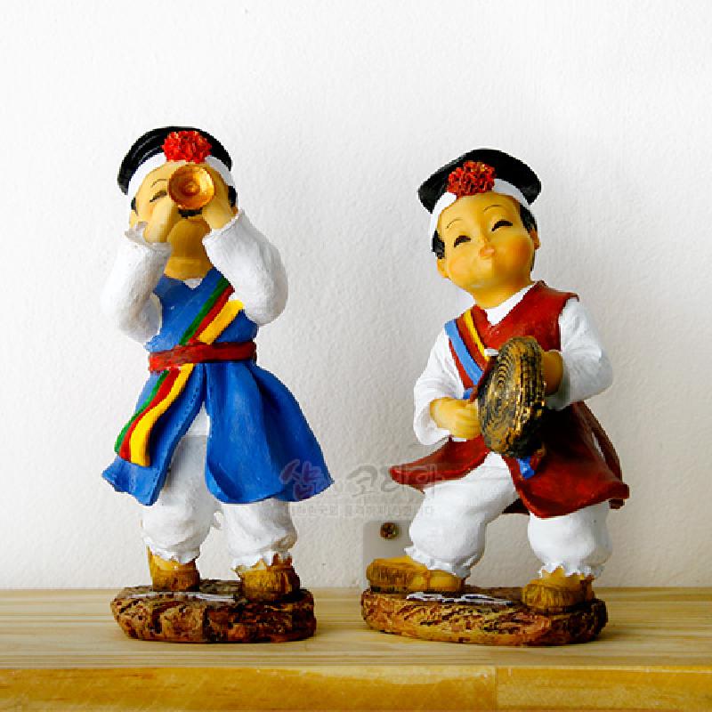 전통 악기를 연주하는 아이를 형상화한 레진 소재 인형, 원색 한복과 무지개 색 띠 장식이 특징인 공예품.