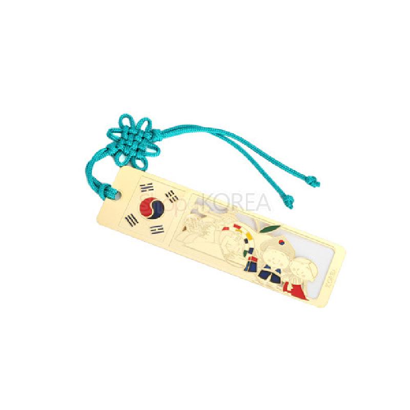 금속 재질의 금장 책갈피, 태극기 문양과 전통의상 인물 도안, 청록색 전통 매듭 끈 장식.