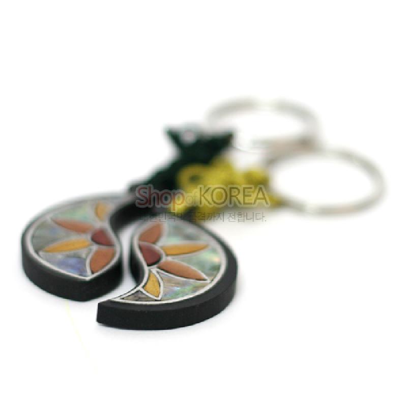 흑단 바탕 위에 자개 상감으로 연꽃쌍 문양을 넣은 반달 형태의 금속 고리 장식 열쇠고리.