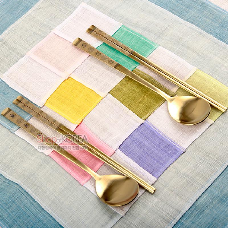 골드 톤 티타늄 금속으로 제작된 수저·젓가락 세트, 손잡이에 십장생 문양 각인과 화사한 색실 패치 바탕이 특징인 구성.