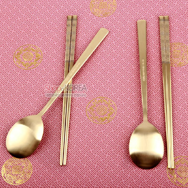 티타늄 소재의 수저와 젓가락 2인 세트, 손잡이 부분에 섬세한 십장생 문양과 무광 골드 톤이 특징인 금속 식기.