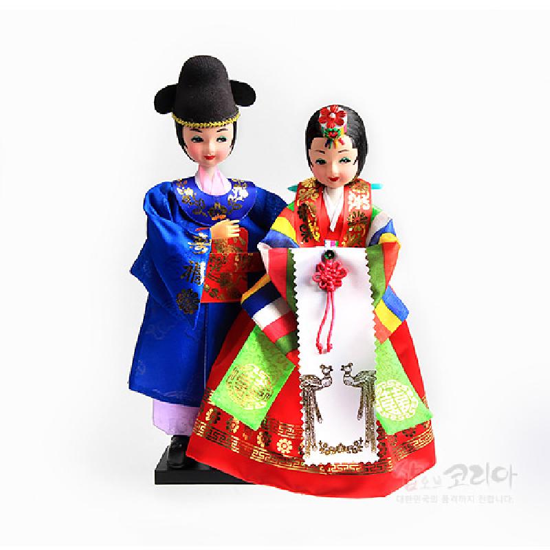 비단 소재의 전통 혼례 한복을 입은 신랑신부 인형, 봉황·전통문양 금박과 오방색 단청색 대비가 돋보이는 장식 인형.