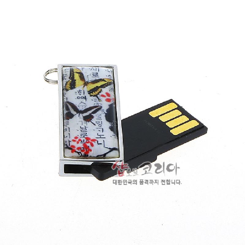금속 테두리 안에 한글 서예 배경 위 노랑·흑색 나비와 붉은 꽃 문양이 인쇄된 직사각형 장식의 USB 메모리. 금속 테두리 안에 한글 서예 배경 위 노랑·흑색 나비와 붉은 꽃 문양이 인쇄된 직사각형 장식의 USB 메모리.