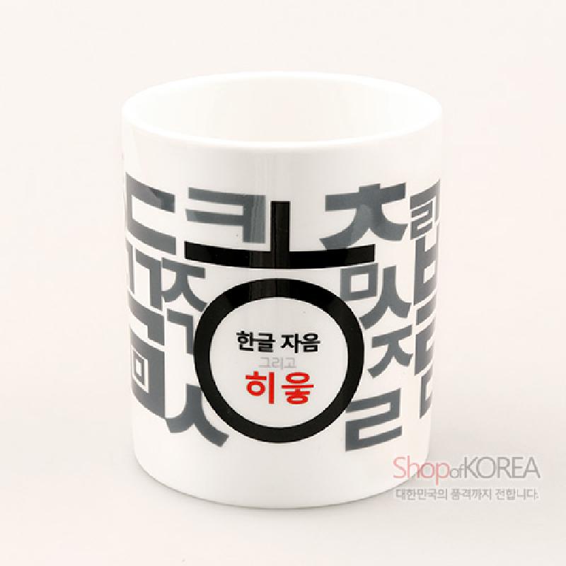 백색 도자 재질에 검은색과 회색 한글 자음 패턴, 붉은색 히읗 글자가 인쇄된 머그컵.