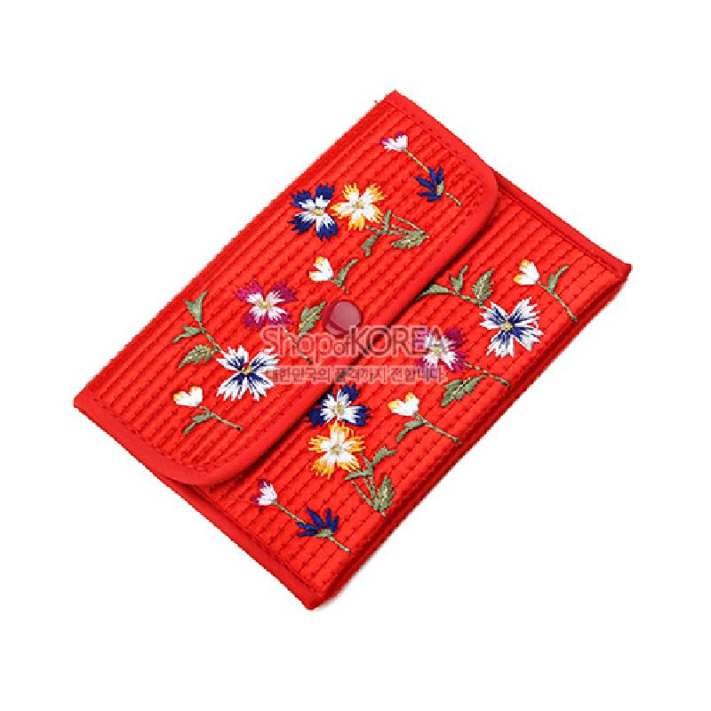 붉은색 누비 천에 다채로운 실로 수놓은 꽃자수 문양과 똑딱이 단추 여밈이 특징인 동전지갑.