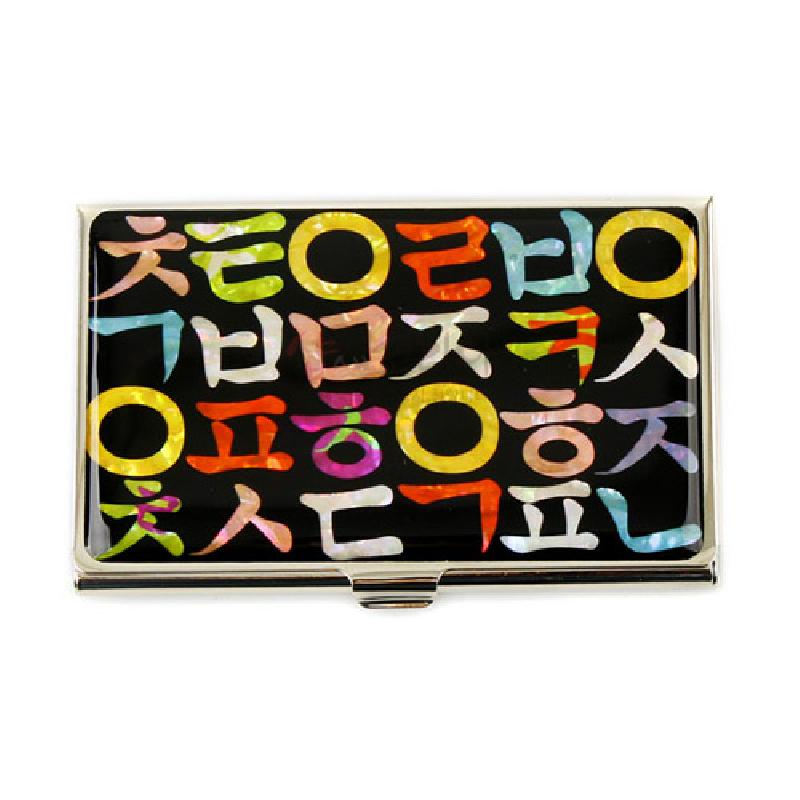 검은 바탕 위에 다채로운 자개 상감으로 한글 자모 문양을 배열한 금속 명함케이스.