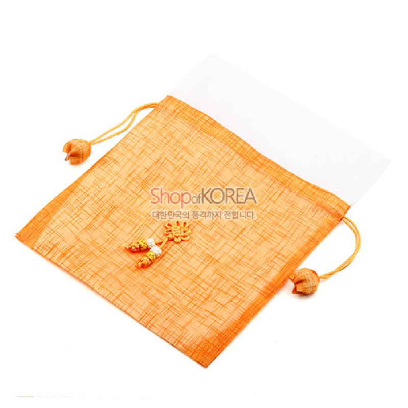 황색 모시 원단으로 만든 복주머니로, 흰색 상단 배색과 매듭 장식, 조롱박 모양 끈 장식이 어우러진 전통 공예품.