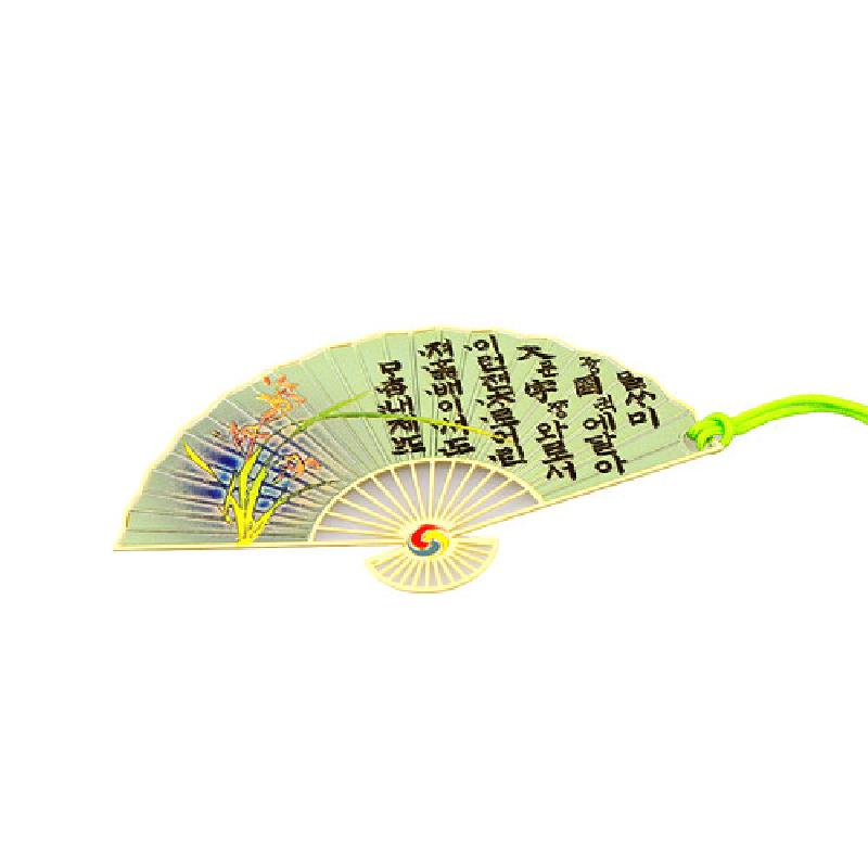 금속 재질 부채 모양 책갈피에 연녹색 바탕, 난초 문양과 훈민정음 서체, 태극 문양 손잡이, 형광 녹색 끈 장식.