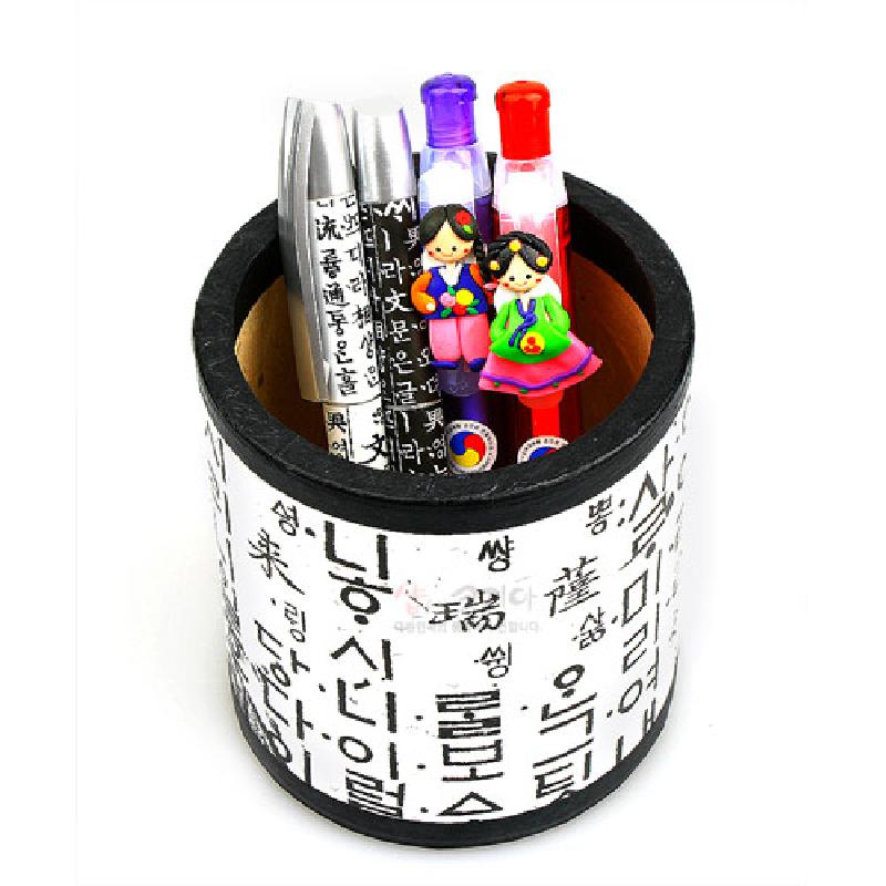 흰색 바탕 위에 검은색 훈민정음 한글 글씨 문양이 둘러진 원형 종이 재질 연필꽂이.