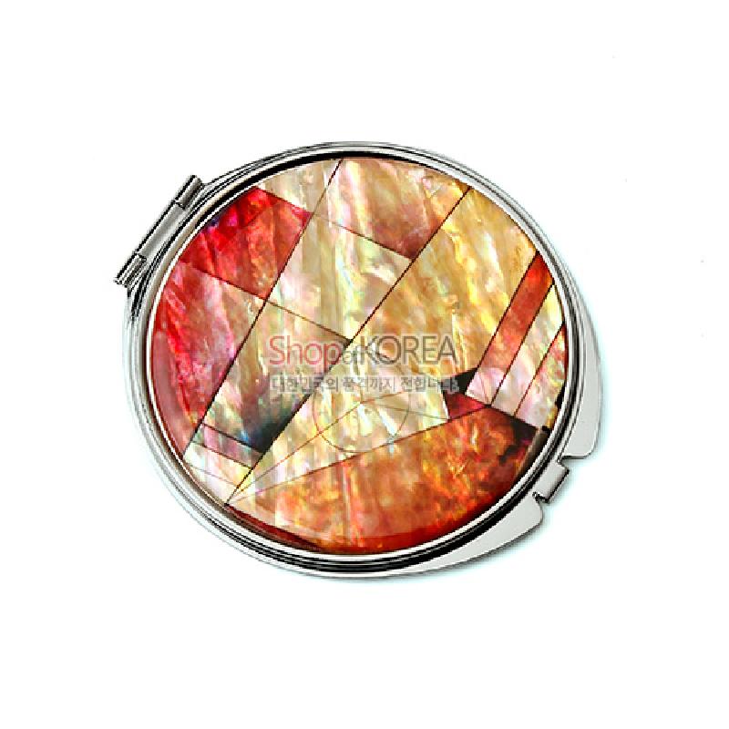 은은한 광택의 자개를 기하학적 조각보 패턴으로 상감한 원형 금속 손거울.