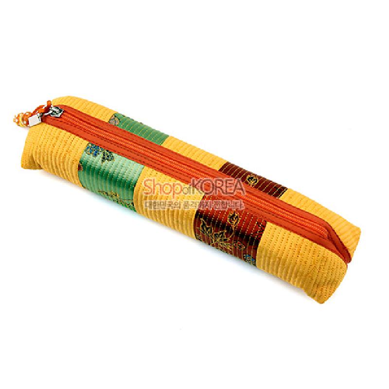 노란 누비 원단을 바탕으로 녹색·갈색 패치와 꽃무늬 직조가 어우러진 지퍼형 천연섬유 필통.