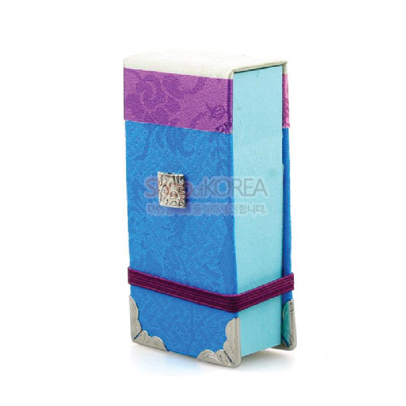 청색과 자주색 비단 천을 덧댄 직사각형 포스트잇 커버, 금속 모서리 장식과 은색 장식판, 자주색 끈이 더해진 디자인.