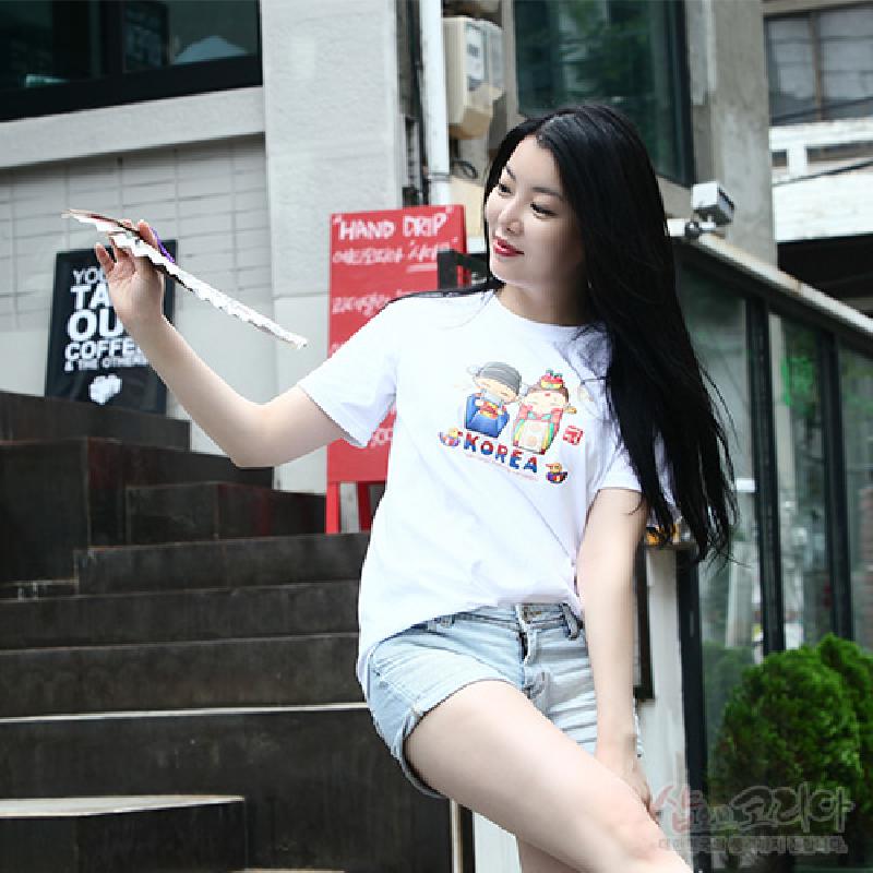 한복 차림 신랑신부 캐릭터와 알록달록한 전통 문양이 입체 발포 기법으로 표현된 흰색 면 티셔츠.